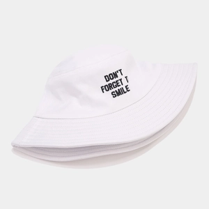 White cotton bucket hat featuring black embroidered Don't Forget To Smile slogan text