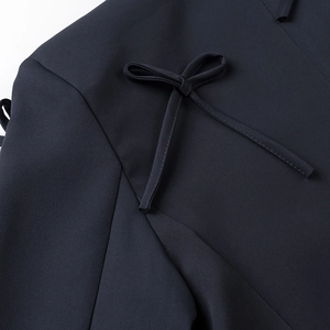 Detailed close-up of a navy blue bow tie decoration on a designer blazer jacket