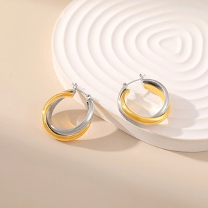Detail of mixed gold and silver interlocking hoop earrings on a spiral texture tray