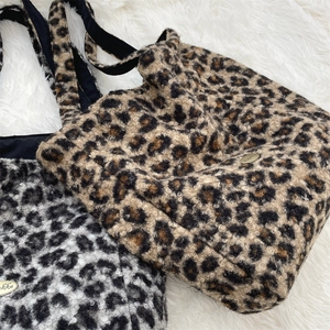 Close-up of leopard print faux shearling tote bags with gold logo nameplate