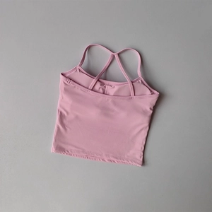 Détail des fines bretelles croisées d'un débardeur de yoga rose et respirant