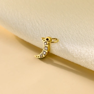 Macro shot of gold crescent moon pendant with micro pavé diamonds and jump ring connector