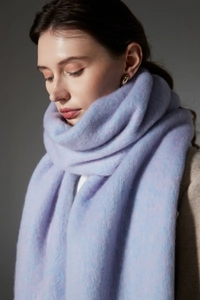 Close-up of soft lavender bouclé textured scarf with chunky fringe details and plush wool feel
