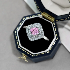 Close-up of pink square zircon ring with double halo in a luxury blue jewelry box