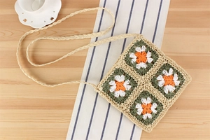 Détail du sac bandoulière au crochet fait main avec motifs floraux et sangle tissée