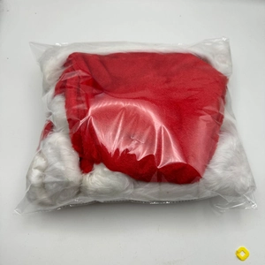 Close-up of a red and white plush Christmas hat packed in a transparent plastic bag