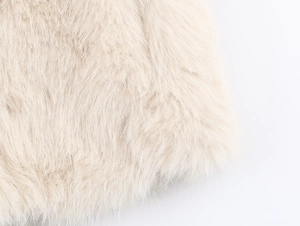 Macro shot of high-density cream faux fur material showing soft plush texture and fibers
