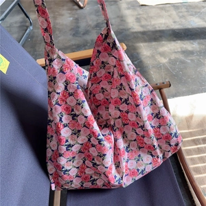Detail of floral canvas tote bag with vintage rose print resting on an outdoor chair