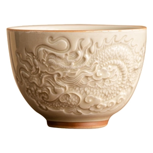 Ceramic dragon relief teacup with minimalist beige glaze and brown edge on white background