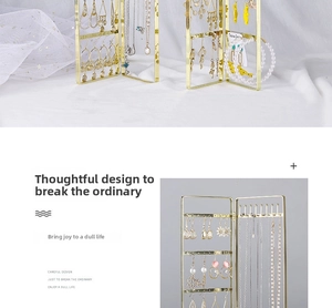 Close-up of golden multi-tier metal jewelry organizer with hooks and earring holes