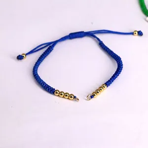 Detail of blue braided Milan rope bracelet with gold beads and adjustable sliding knot