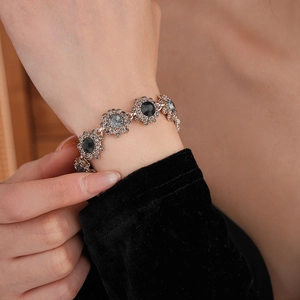 Close-up of vintage flower bracelet featuring grey crystals and pavé set small diamonds