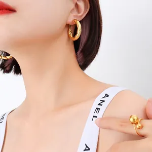 French minimalist 18k gold plated twisted hoop earrings and double ball open ring on model