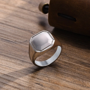 Macro shot of silver hexagonal signet ring for men on dark wood textured background