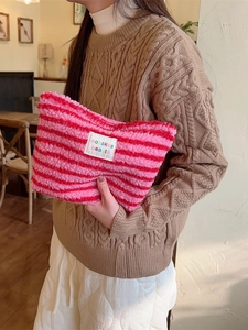Pink and red striped plush cosmetics bag with soft fleece texture for travel storage