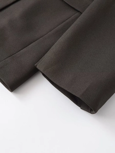 Detailed close-up showing the cuff craftsmanship and woven texture of the dark brown blazer