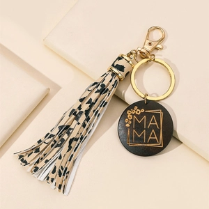 Detail of leopard print tassel and engraved MAMA wooden charm on a gold keychain