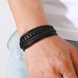 Gros plan d'un bracelet multicouche pour homme en cuir tressé noir au style rétro