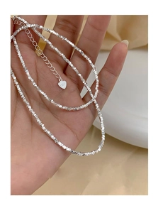 Detailed macro view of S925 sterling silver crushed beads necklace with engraved heart tag