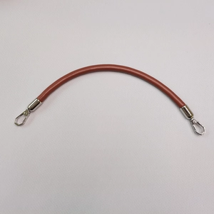Brown leather handbag strap detail with metal swivel hooks and curved design