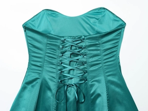 Dettaglio dell'abito in raso verde scuro con design a corsetto stringato regolabile