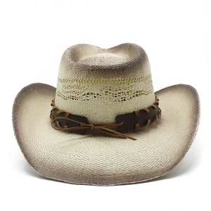 Détail d'un chapeau de cowboy tissé avec des bords marron usés et un ruban en cuir brun