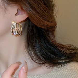 Boucles d'oreilles créoles dorées à trois couches serties de zircons étincelants