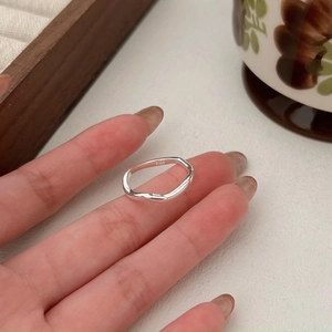 Macro shot of minimalist S925 sterling silver wavy ring with smooth polished finish