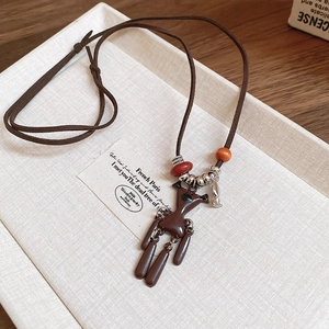 Detail of vintage bear pendant necklace with brown cord and decorative beads