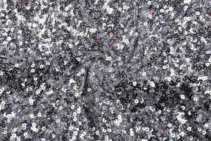 Gros plan de paillettes argentées et noires sur le tissu en mesh d'une robe moulante