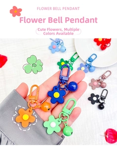 Close-up of colorful floral bell keychains with metal U-shape clasps and ring charms