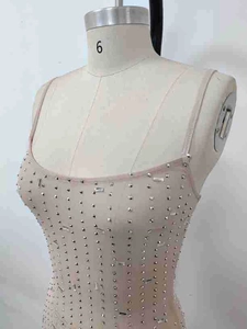 Detail of hand-applied silver rhinestones and crystals on nude mesh party dress fabric