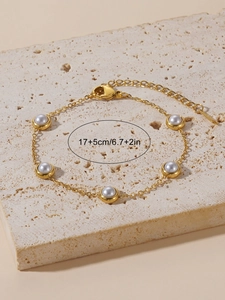 Detail of gold pearl bracelet with 17+5cm extension chain on beige stone display