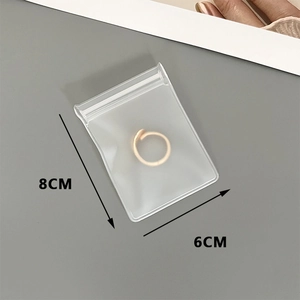 Detailed view of 6x8cm transparent EVA jewelry pouch with a ring inside for storage