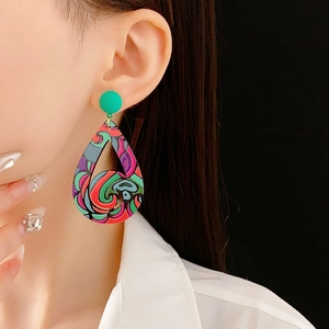 Gros plan sur des boucles d'oreilles bohèmes en forme de goutte avec des motifs abstraits colorés