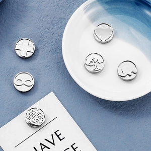 Detailed macro view of 15mm stainless steel charms with heart and elephant cutouts