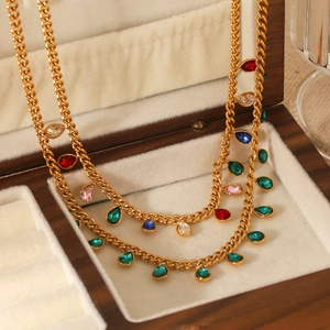 Detail of gold double-layer necklace with colorful teardrop zircons on velvet padding