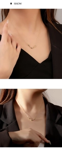Primo piano di una collana a V dorata minimalista su una modella che indossa un blazer nero