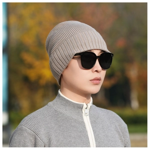 Detail of light khaki ribbed knit beanie showing textured weave pattern on a male model