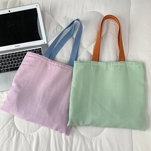 Detail shot of striped seersucker tote bag with contrasting handles and textured surface
