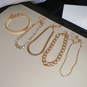 Vue détaillée du lot de cinq bracelets dorés comprenant des mailles gourmettes et serpent