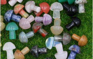 Various colorful 2cm mini natural stone mushroom figurines on green grass background
