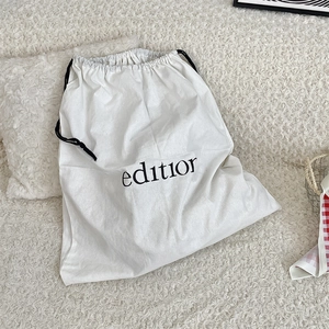 Detail of white cotton drawstring dust bag with editior text on soft texture