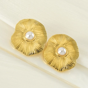 Gros plan de boucles d'oreilles pétales vintage dorées avec perle centrale