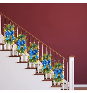 Close-up of Christmas staircase swags with pine needles, blue berries and LED lights