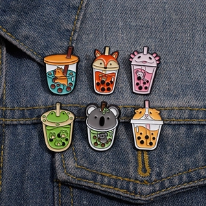 Detail of cute animal boba tea enamel pins pinned on a blue denim jacket fabric