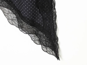 Détail de la bordure en dentelle noire cousue avec un tissu à pois blancs sur un haut chic