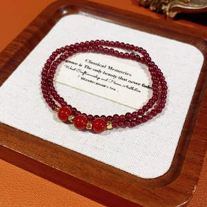 Detail of double-layer garnet bead bracelet with agate accents and gold spacers