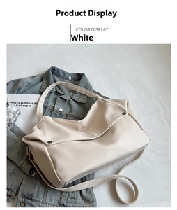 Detailed view of large off-white tote bag with pebbled leather texture and metal rivets