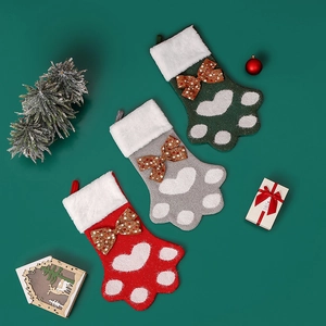 Trois chaussettes de Noël créatives en forme de patte de chien en rouge, gris et vert